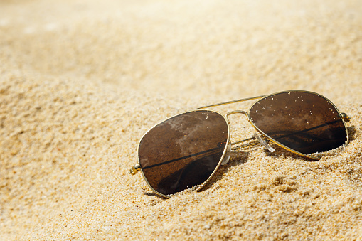 Sunglasses is lying in the sand