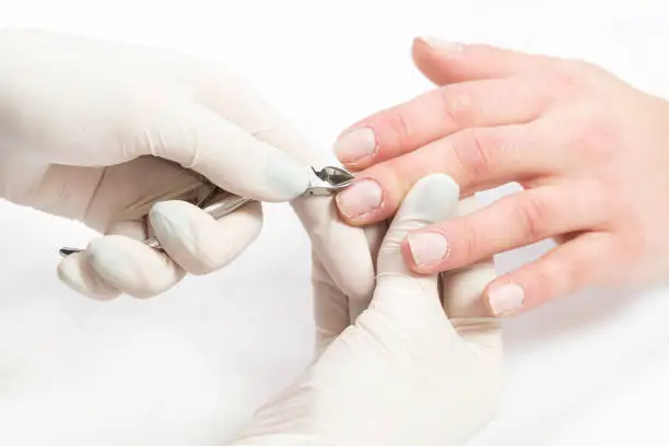 Female hand manicure procedure shot in closeup in a beauty salon.