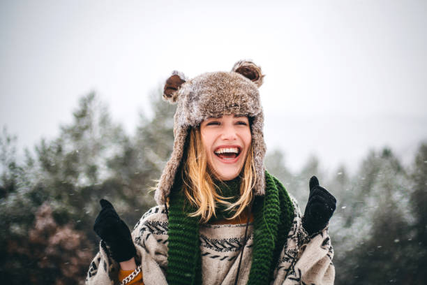 a mulher nova alegre aprecia o dia frio do inverno nas montanhas - scarf women hat warm clothing - fotografias e filmes do acervo