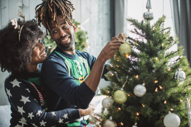 istock Couple decorating Christmas tree 1183638102