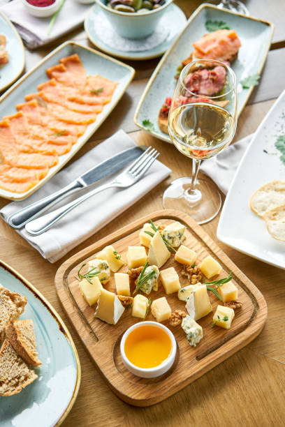 istock Cheese plate. Focus on delicious cheese mix with walnuts, honey on wooden table. Various snacks and antipasti on the table. Restaurant menu. 1183643505