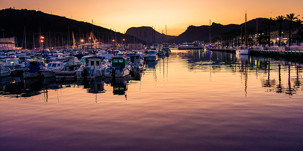 Beautiful sunset in the marina of Cartagena, Murcia, Spain. Calm in the boats docked in the pontoons.