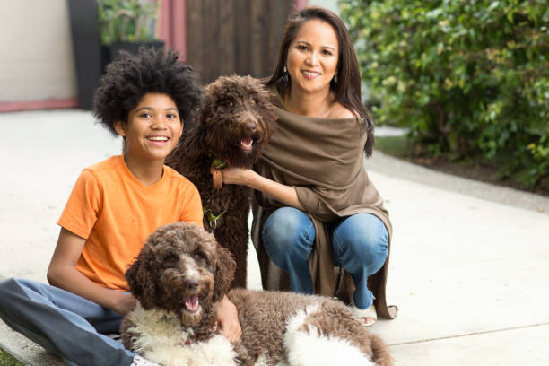istock Mother and her son laughing and playing with their dog. 1183656418