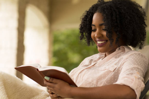 istock Woman smiling holding a book. 1183657050