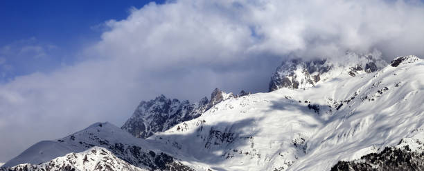 istock Snow mountains in clouds in winter sun day 1183657330