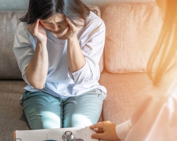 mal di testa, paziente con emicrania, donna che invecchia in menopausa depressa stressante con disturbo d'ansia, vertigini, attacco di panico o sintomo di vertigini cervicali che vede il medico per il trattamento medico - doctor emotional stress worried healthcare and medicine foto e immagini stock