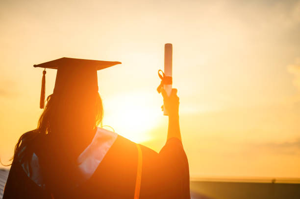 i laureati indossano un cappello nero per congratularsi per la laurea - graduation university degree learning foto e immagini stock