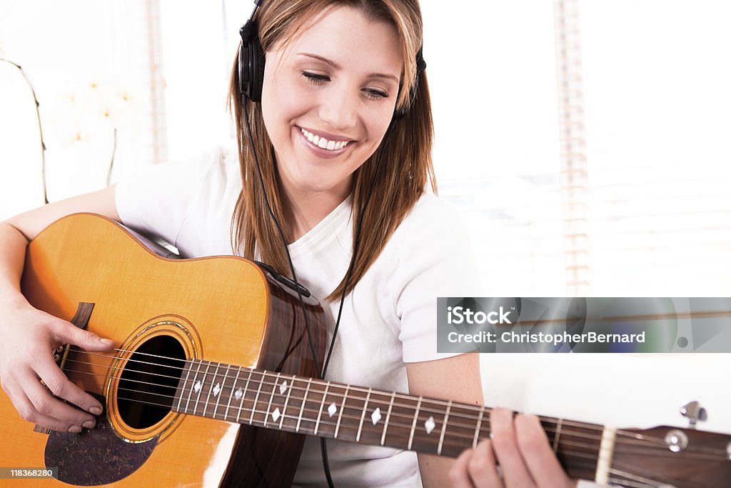 Souriante jeune femme jouer de la guitare - Photo de Accord - Écriture musicale libre de droits