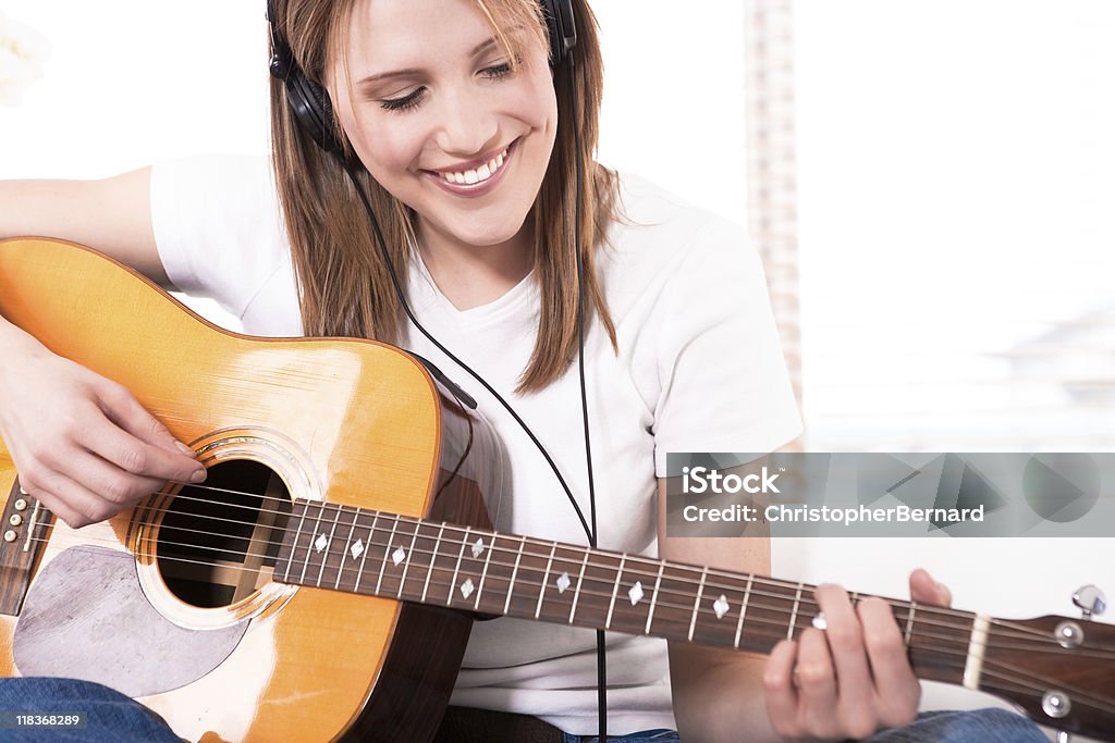 Smiling young woman playing the guitar  20-24 Years Stock Photo