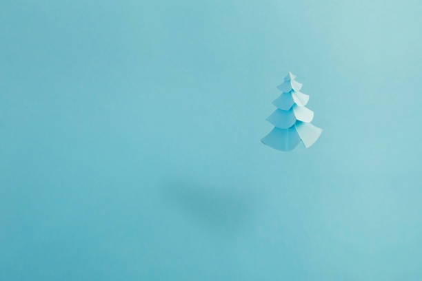 istock paper Christmas tree on blue background 1183692371