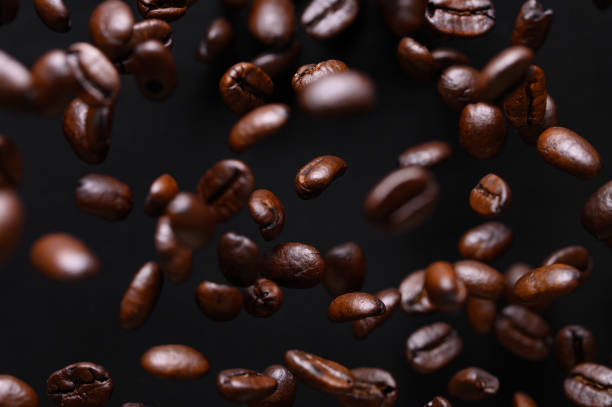 istock black coffee grains while cooking. Iced in the air on a black background for design 1183693137