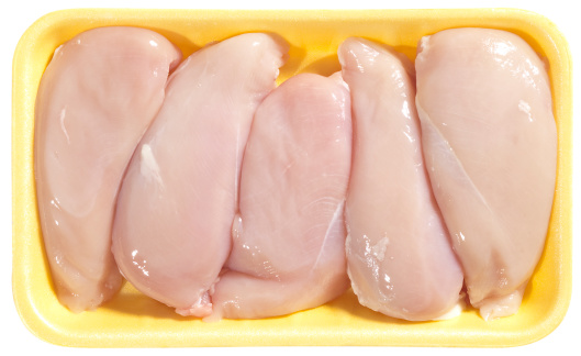 Fresh Chicken Whole Legs set, in Foam Tray Pack, on black wooden table background, with copy space for text