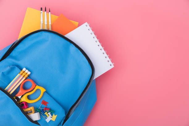 синий рюкзак мешок для образования детей на розовом фоне - scissors red school supplies isolated стоковые фото и изображения