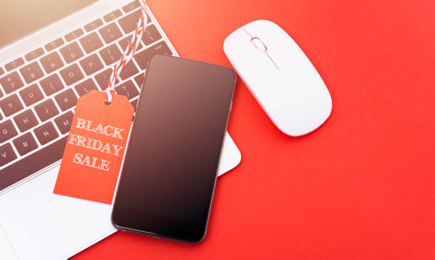 istock Black Friday Sale text on red tag have mobile smart phone over laptop computer 1183697964