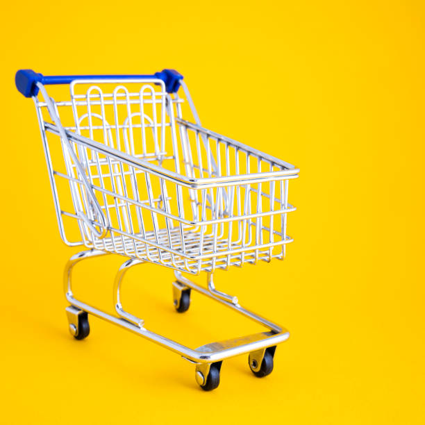 istock empty shopping cart over yellow background 1183699145