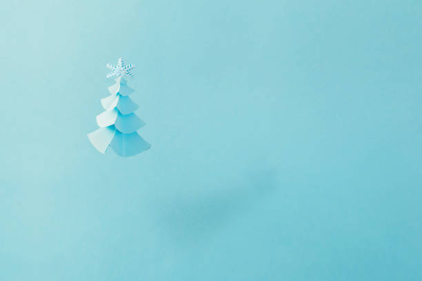 istock paper Christmas tree on blue background 1183701066