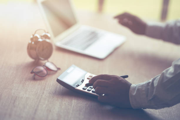 istock businessman with hand holding pen working on calculator 1183702234