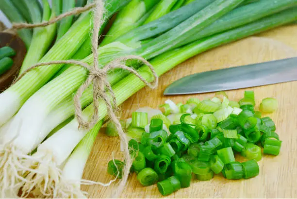 Spring onions are rich in vitamins,minerals and natural compound.
Green onions or Spring onions on wooden board cutting.