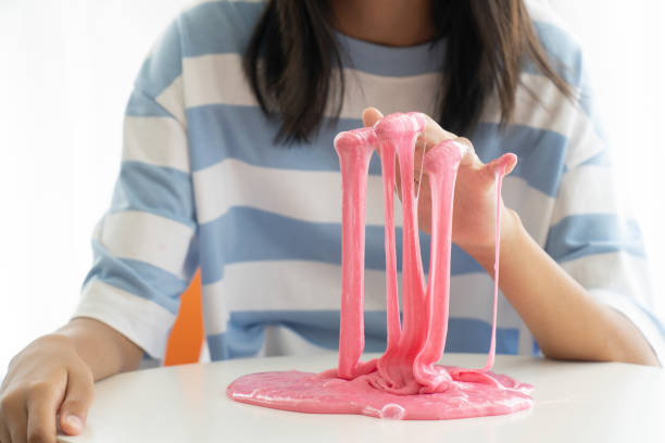 istock Hand Holding Homemade Toy Called Slime, Kids having fun and being creative by science experiment 1183704475