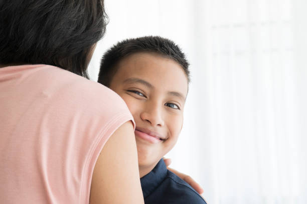 istock Happy Boy Hug His Mom Smiling and Looking to Camera 1183704518
