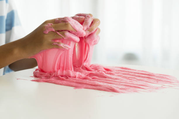 istock Hand Holding Homemade Toy Called Slime, Kids having fun and being creative by science experiment 1183704597