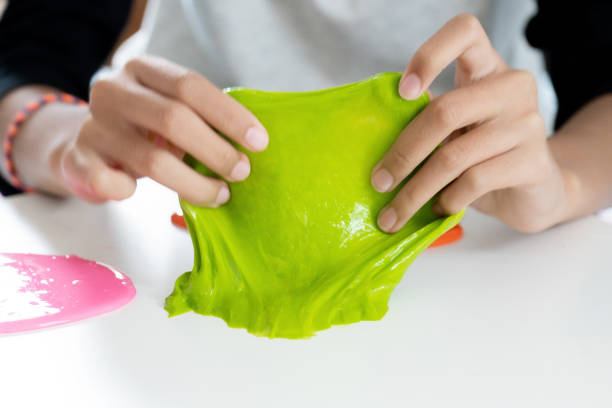 istock Hand Holding Homemade Toy Called Slime or Goop, Kids having fun and being creative by science experiment 1183706249