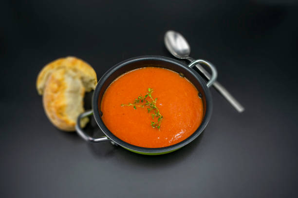 Mediterranean tomato soup with blurred background on black background.