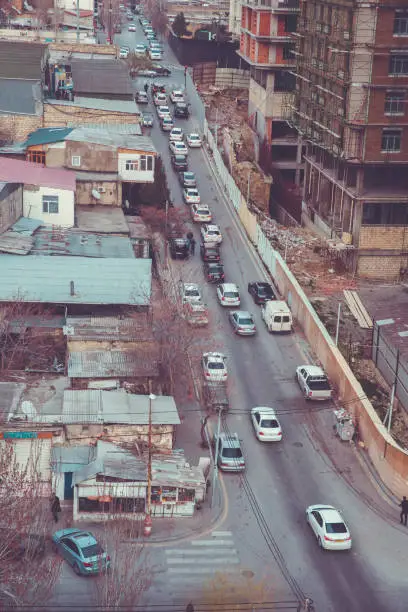 Photo of top view . cars are jammed on the road . view from above . cloudy evening . In the evening . Cold building background.Old houses are newly built buildings . Traffic jammed on the road .