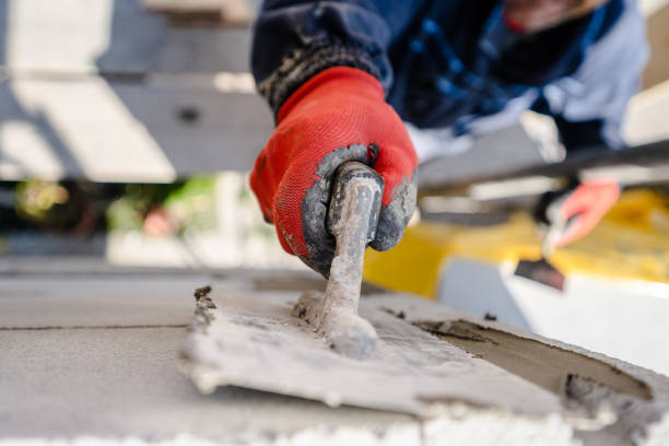 オートクレーブの気口コンクリートaacレンガの高角を手元に閉じた粘着性セメントセメントを塗布したコテセメントモルタルで壁を漆喰する建設労働者は、ツールを屋外に保持します - work tool hand tool construction repairing ストックフォトと画像