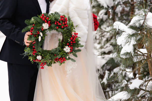 겨울 결혼식입니다. 크리스마스 화환을 들고 신부와 신랑 - christmas wedding bride winter 뉴스 사진 이미지