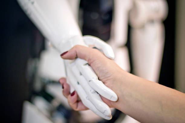 istock Shaking hands with a robot. A woman meets a robot . 1183715392