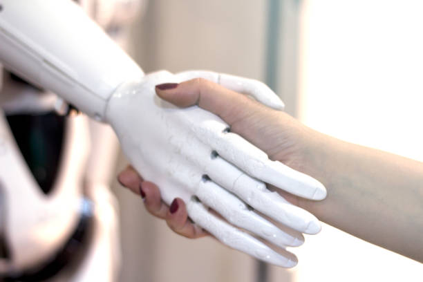 istock Shaking hands with a robot. A woman meets a robot . 1183715396
