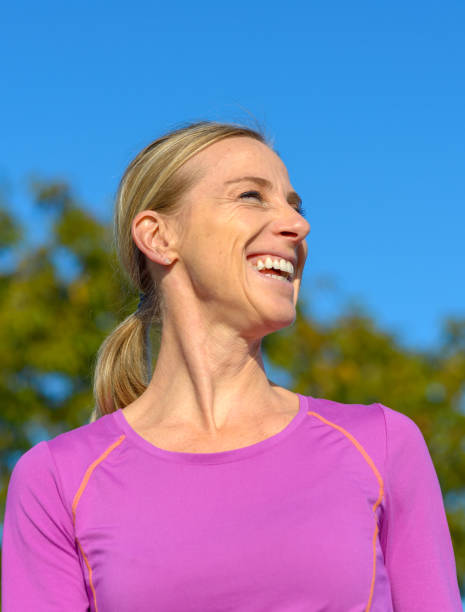 istock Happy blond woman standing outdoors laughing 1183715458