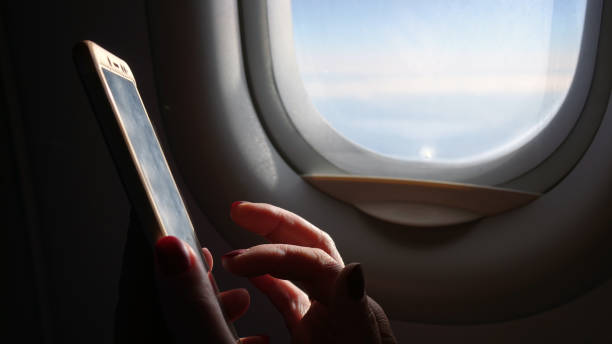 istock Woman on the plane working with a smartphone . 1183715808