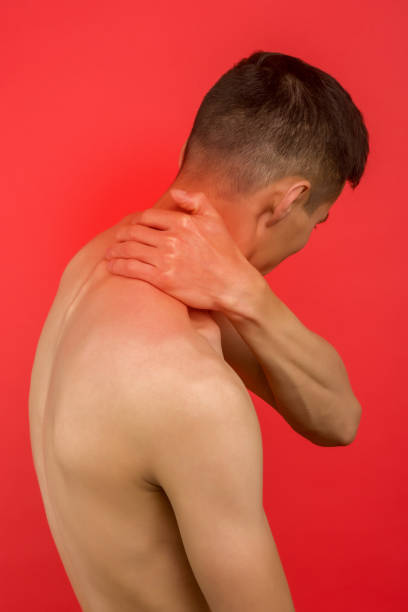 asian man suffering from pain in neck. symptom of cervical chondrosis. inflammation of vertebra, back view - inflammation back physical therapy isolated on white imagens e fotografias de stock