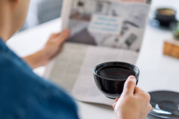 istock a man reading newspaper and drinking coffee in the morning 1183718773