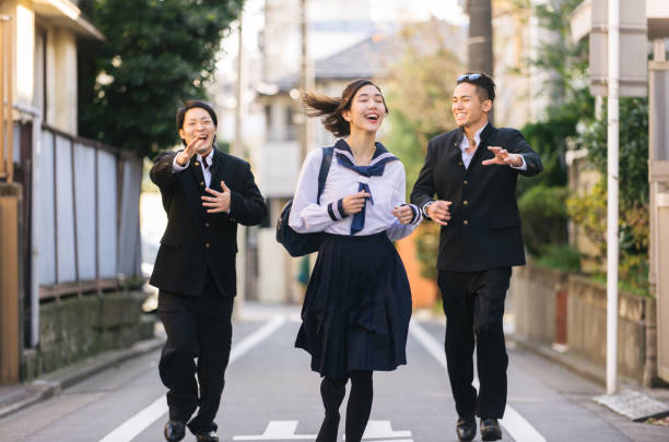 Yung japanese students with school uniform bonding outdoors - Group of asian teenagers having fun
