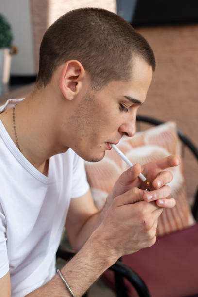 istock Portrait of young man lighting a cigarette 1183720879