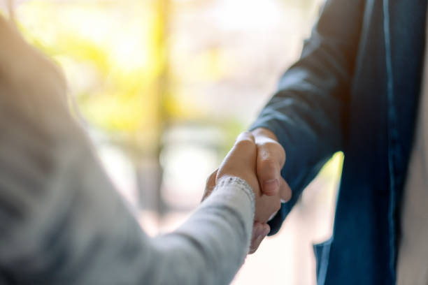 two people shaking hands - hand shake imagens e fotografias de stock