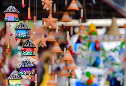 Children's colourful small house toys hanging on strings at a market stall at Queen Victoria Market, Melbourne, Australia