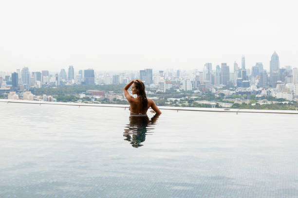 istock Woman relaxing on a rooftop pool 1183725184