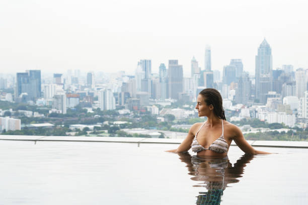 istock Woman relaxing on a rooftop pool 1183725207