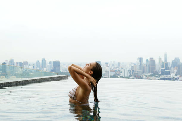istock Woman relaxing on a rooftop pool 1183725798