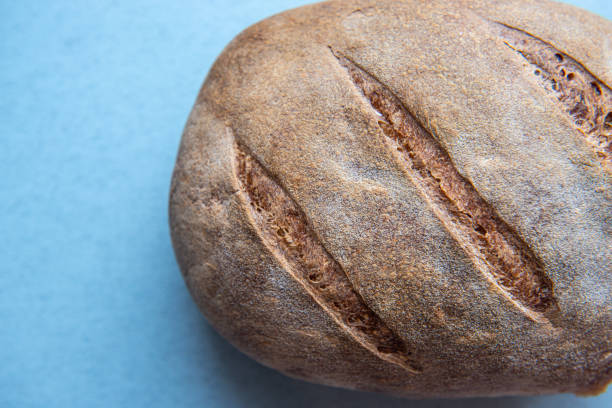 istock freshly baked bread isolated on blue background, top view 1183726079