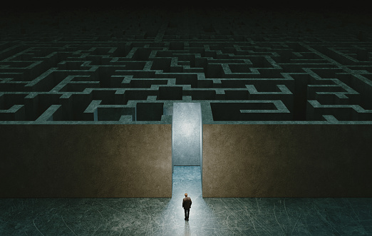 Businessman standing in front of the entrance to the maze. Solution concept
