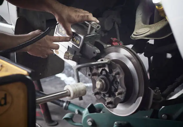 Disc brake system repair. Brake disc with grinding machine and vehicle brake-disc.