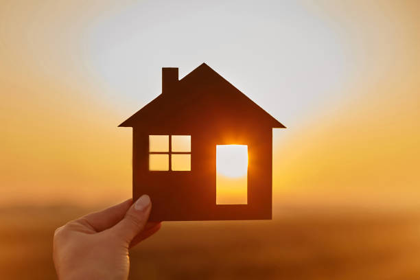 la main de femme retient la maison en bois contre le soleil - problème de logement photos et images de collection