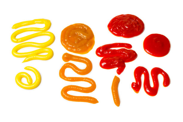 istock Ketchup and yellow sauce splashes isolated on white background. 1183733344