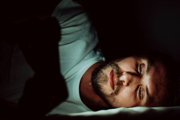 istock Young man in bed with a phone 1183733924