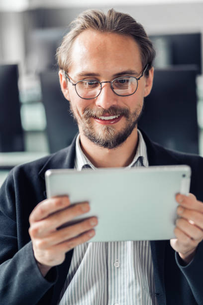istock Young handsome man in glasses with tablet. 1183733982